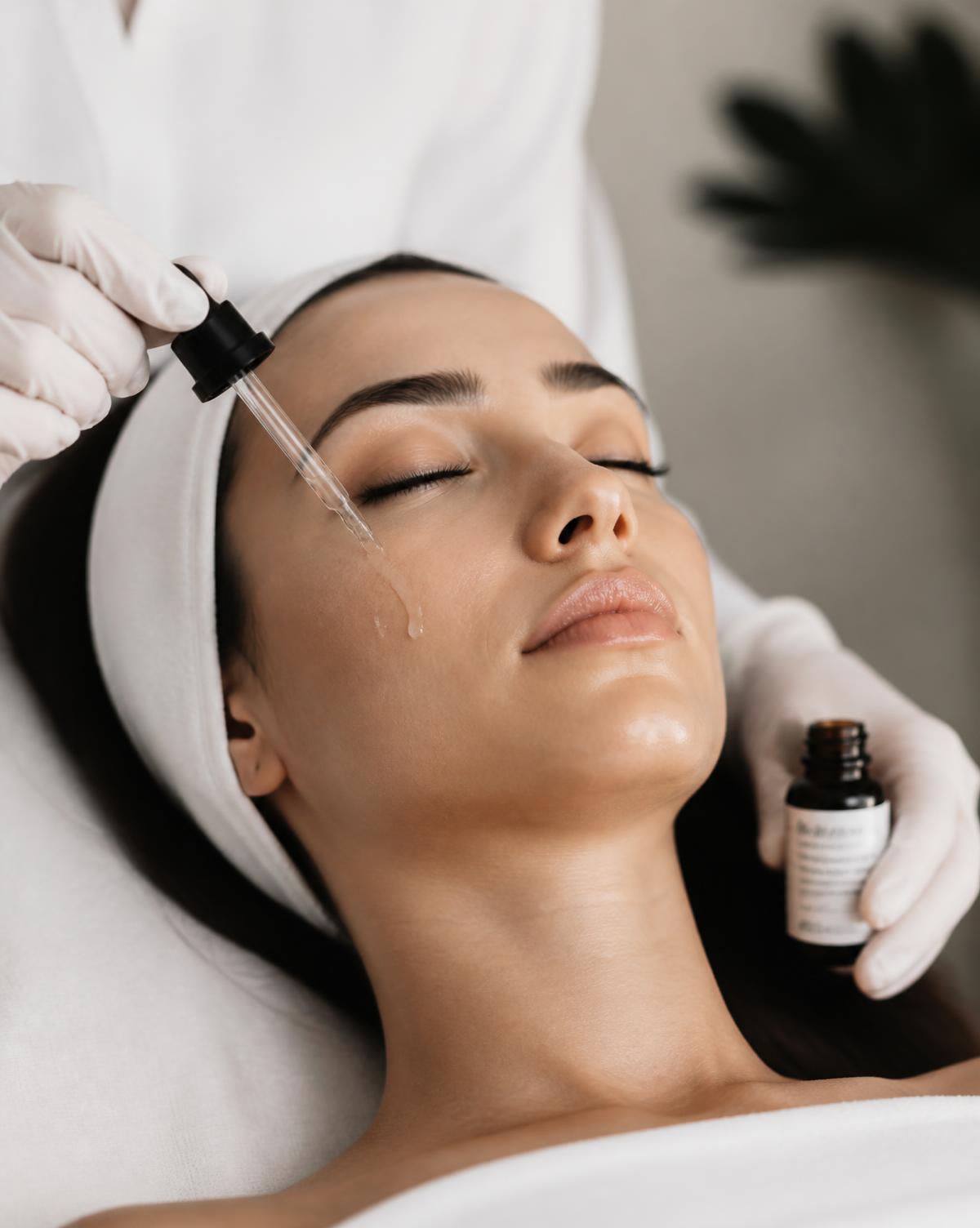 Aesthetician applying serum during a facial treatment